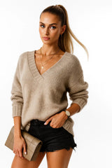 Woman wearing a black V-neck knit sweater with fitted black jeans