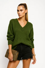 Woman wearing a black V-neck knit sweater with fitted black jeans